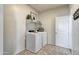 Functional laundry room with modern white washer and dryer, plus convenient shelving for storage at 5106 E Umber Rd, San Tan Valley, AZ 85143