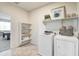 Bright laundry room with white appliances, open shelving, and decorative accents at 5106 E Umber Rd, San Tan Valley, AZ 85143