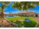 Spacious backyard featuring a lush lawn, mature trees, inviting pool and patio seating, great for relaxation at 5462 W Geronimo St, Chandler, AZ 85226