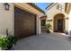 This home features a two-car garage and an arched doorway leading to the front entry, with potted plants at 5550 N Luna Dr, Eloy, AZ 85131