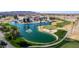 An aerial view of the beautiful golf course with a large pond, palm trees, and stunning desert mountain views at 5550 N Luna Dr, Eloy, AZ 85131