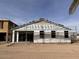 Exterior view of a new construction home with scaffolding and protective wrap at 5583 S 240Th Ln, Buckeye, AZ 85326