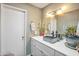 Well lit bathroom with a marble countertop, decorative sink, and white cabinets at 620 S Allred Dr, Tempe, AZ 85288