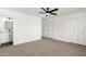 Spacious bedroom featuring neutral carpet, a ceiling fan, and access to the bathroom at 6655 E Rustic Dr, Mesa, AZ 85215