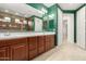 Spacious bathroom featuring double sinks, wood cabinets, tile floors, and decorative green walls at 6656 W Springfield Way, Florence, AZ 85132