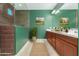 Well-lit bathroom with walk-in shower, wood cabinetry, double sinks, and stylish decor at 6656 W Springfield Way, Florence, AZ 85132