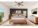 Modern bedroom with accent wall, plush king bed, and ample natural light from large windows at 6656 W Springfield Way, Florence, AZ 85132