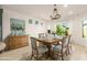 Charming dining room with rustic wood table, elegant chandelier, and bright windows with views of the backyard at 6656 W Springfield Way, Florence, AZ 85132