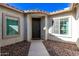 Inviting entryway features a stylish front door flanked by windows, set amidst desert landscaping at 6656 W Springfield Way, Florence, AZ 85132