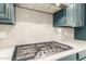 A close up of the kitchen features gray cabinets, white counters, stainless steel gas range, and white subway tile backsplash at 6656 W Springfield Way, Florence, AZ 85132