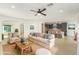 Open-concept living room with light color palette, plush seating, ceiling fan, and seamless flow to the kitchen at 6656 W Springfield Way, Florence, AZ 85132