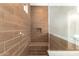 Modern walk-in shower with horizontal brown tile, a built-in bench, and a glass enclosure at 6656 W Springfield Way, Florence, AZ 85132