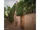 Exterior view of a rustic wall adorned with lush greenery, evoking charm and tranquility and a wooden gate at 6711 E Camelback Rd # 81, Scottsdale, AZ 85251