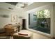 Bright sitting area with an oversized window offering views of a peaceful courtyard with modern sculpture at 6711 E Camelback Rd # 81, Scottsdale, AZ 85251