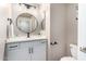 Stylish powder room with a modern sink, vanity, and elegant round mirror at 6745 N 93Rd Ave # 1166, Glendale, AZ 85305