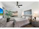 Bright bedroom features a ceiling fan, neutral decor, and a view to the outdoors at 678 E Cobble Stone Dr, Queen Creek, AZ 85140