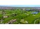 Scenic aerial shot of lush green golf course with sand traps and water features, surrounded by houses and mountains at 678 E Cobble Stone Dr, Queen Creek, AZ 85140