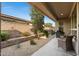 Covered patio area with a grill, seating, and a nicely landscaped side yard at 678 E Cobble Stone Dr, Queen Creek, AZ 85140