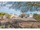 Spacious backyard, gravel landscaping, storage unit, and partial view of the mobile home at 690 S 92Nd Pl, Mesa, AZ 85208