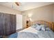 Cozy bedroom featuring wood-look flooring, ceiling fan, and closet with modern doors at 690 S 92Nd Pl, Mesa, AZ 85208