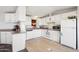 Well-lit kitchen with white cabinetry, appliances, and laminate countertops for functional style at 690 S 92Nd Pl, Mesa, AZ 85208