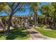 Path to the community pool, featuring a pergola, manicured shrubs and mature palm trees at 7009 E Acoma Dr # 1046, Scottsdale, AZ 85254