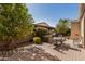 Serene backyard featuring a brick patio, outdoor dining set, lush landscaping, and a grill for outdoor cooking at 815 E Laddoos Ave, San Tan Valley, AZ 85140