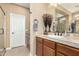 Bathroom featuring a tiled vanity, a decorative mirror, and a white door at 815 E Laddoos Ave, San Tan Valley, AZ 85140