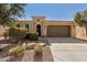 Charming single-story home with desert landscaping, a brown two car garage, and an arched entryway at 815 E Laddoos Ave, San Tan Valley, AZ 85140