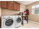 Well-equipped laundry room with updated machines, ample cabinet space, and a convenient folding area for easy chores at 815 E Laddoos Ave, San Tan Valley, AZ 85140