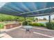 Outdoor kitchen with stainless steel grill, countertop space, and shaded seating area for entertaining guests at 815 E Laddoos Ave, San Tan Valley, AZ 85140