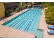 Large swimming pool for exercise with lane markers, surrounded by lounge chairs and greenery at 815 E Laddoos Ave, San Tan Valley, AZ 85140