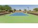 Well-maintained tennis court with green and blue surface, surrounded by manicured landscaping and lighting at 815 E Laddoos Ave, San Tan Valley, AZ 85140