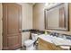 Cozy powder room features a vanity with tiled backsplash and decorative mirror at 8214 E Kael St, Mesa, AZ 85207