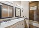 Bathroom featuring dual mirrors, vanity, tile accents, and separate bathtub at 8214 E Kael St, Mesa, AZ 85207