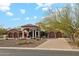 Beautiful home exterior with arched entryway, stone accents, fountain, and well-manicured desert landscaping at 8214 E Kael St, Mesa, AZ 85207