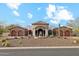 Beautiful home exterior with arched entryway, stone accents, fountain, and well-manicured desert landscaping at 8214 E Kael St, Mesa, AZ 85207