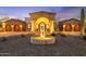 Gorgeous home showcasing stone accents, an arched entryway, manicured landscaping and a circular fountain at 8214 E Kael St, Mesa, AZ 85207