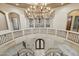 Grand foyer with dual staircases, chandelier, arched doorways, and tile flooring at 8214 E Kael St, Mesa, AZ 85207