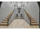 Grand foyer with tile floors, wrought iron railing, staircase, statues, high ceilings, and neutral wall color at 8214 E Kael St, Mesa, AZ 85207