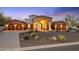 Majestic home exterior showcasing grand entrance with stone accents, desert landscaping, and multi-car garages at 8214 E Kael St, Mesa, AZ 85207