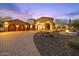 Inviting home exterior displaying a well-manicured lawn, stone accents, and a welcoming driveway for visitors at 8214 E Kael St, Mesa, AZ 85207