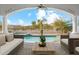 Inviting outdoor living space with a sparkling pool and comfortable seating area under a covered patio at 8214 E Kael St, Mesa, AZ 85207