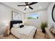 Modern bedroom features a plush bed with stylish decor, a ceiling fan, and natural light from the window at 8432 E Keim Dr, Scottsdale, AZ 85250