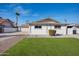 Inviting single-story home featuring a well-manicured lawn, and a freshly painted white exterior at 8432 E Keim Dr, Scottsdale, AZ 85250