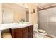 Bathroom featuring a vanity with a white sink, dark wood cabinets and a glass enclosed shower at 8544 E San Lorenzo Dr, Scottsdale, AZ 85258