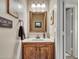 Classic half bath featuring a wood vanity, and a decorative mirror at 8926 W Lockland Ct, Peoria, AZ 85382