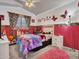 This bedroom features zebra print accents, pink walls, a window, and a bed with colorful bedding at 8926 W Lockland Ct, Peoria, AZ 85382