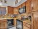 Well-equipped kitchen featuring wooden cabinets, black appliances, tile backsplash, and granite countertops at 8926 W Lockland Ct, Peoria, AZ 85382