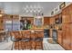 View of the kitchen with wood cabinets, an island with seating, and black appliances at 8926 W Lockland Ct, Peoria, AZ 85382